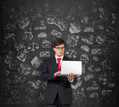 young man holding a computer and working, white pictures symbolizing money around him.