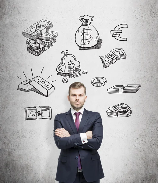 Young man with arms crossed standing and looking in front, black pictures symbolizing money over his head. — Stock fotografie