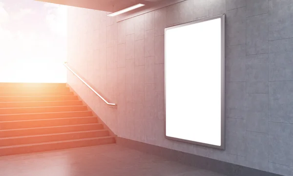 Один вертикальный билборд в метро, лестница влево, город виден — стоковое фото