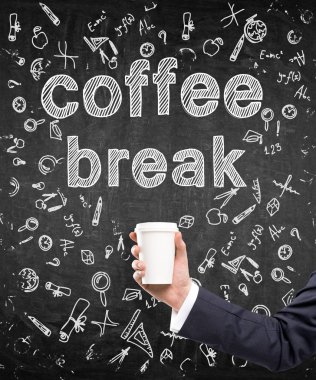 A hand in a black suit holding a paper cup. 'Coffee break' written over it. Black background with different scientific symbols. Concept of coffee break.