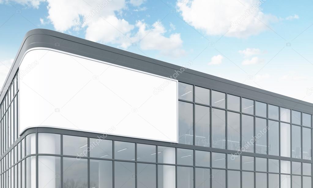 billboard on the facade of a glass and metal office building. Blue sky and clouds at the background. Concept of outdoors advertising. 3D rendering