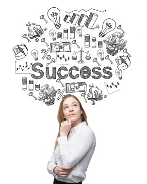A young woman looking up and standing in front of a conrete wall with many different business icons and the word 'success' drawn on it.