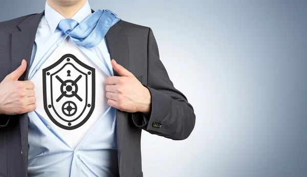 A man in an unbuttoned shirt with an image of shield resembling a safe door on his chest. — Stock Photo, Image