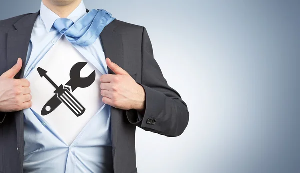 Um homem com uma camisa desabotoada com uma imagem de uma chave de fenda e uma chave cruzada em seu peito . — Fotografia de Stock