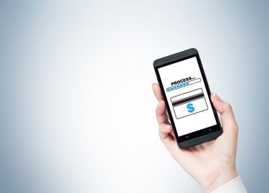 Ekranda 'süreç' kelimesi ve kredi kartı olan bir akıllı telefon tutan bir el.