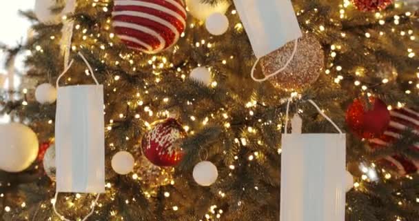 Karácsonyfa 2020-ban ünnepi fényekkel, bálokkal és orvosi maszkokkal díszítve. — Stock videók