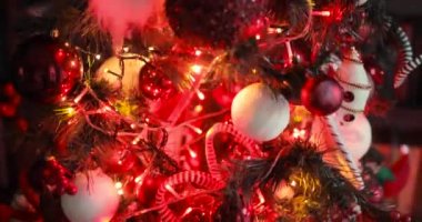 Kırmızı çelenk ve oyuncaklarla süslenmiş Noel ağacı, hareket halindeki kamera..