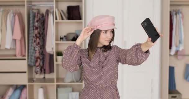 Moda blogcusu kadın portresi soyunma odasında akıllı telefondan selfie çekiyor.. — Stok video