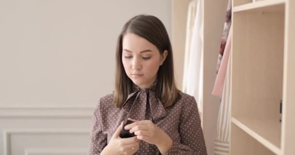 Elegáns fiatal nő permetez parfümöt a testén, közel a szekrényhez otthon.. — Stock videók