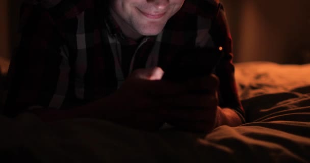 Ο άνθρωπος περιήγηση smartphone βλέποντας social media στο κρεβάτι, closeup τηλέφωνο στα χέρια. — Αρχείο Βίντεο