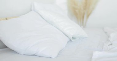 Genç ve güzel bir kadın başını yastığa koyuyor. Yorgun. Yakın plan..