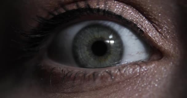 Extreme closeup άποψη των γυναικών άνοιγμα όμορφο μάτι με πράσινη ίριδα στο σκοτάδι. — Αρχείο Βίντεο