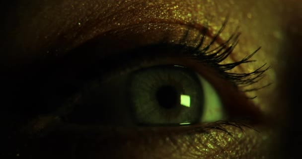 Close-up zicht op vrouwen openen mooi oog in donker knipperend neon licht. — Stockvideo