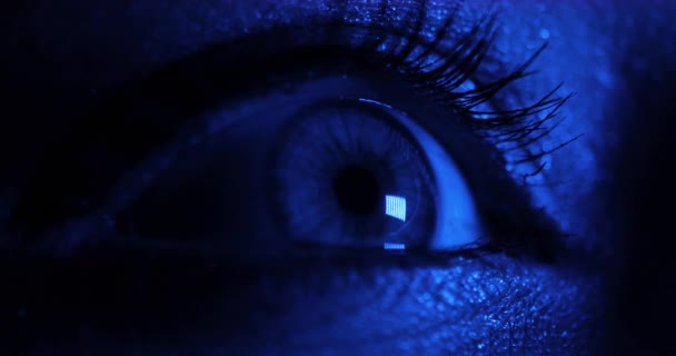 Närbild av kvinnor öppnar vackra ögon i mörkblå och rött ljus. — Stockvideo