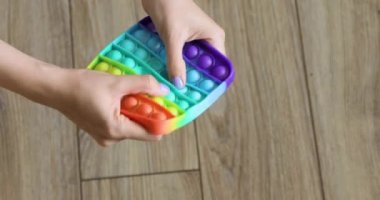 Popit 'le oynayan stresli kişi popo oyuncağını ittirdi. Popüler bir anti-stres oyuncağı oyunu oynamanın üst görünümü
