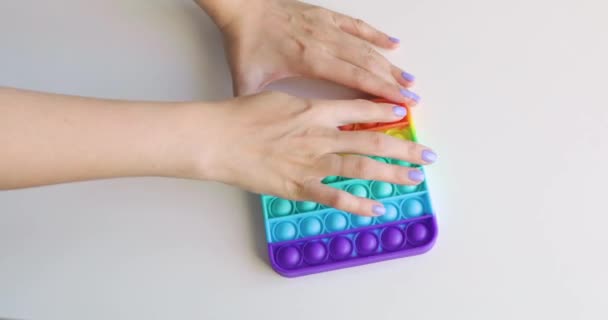 Flicka händer leker med Popit tryck pop bubbla fidget leksak. — Stockvideo