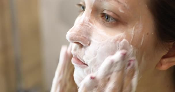 Жінка миє чистку обличчя органічним пінистим мильним засобом, крупним планом. Процедура краси та концепція догляду за шкірою . — стокове відео