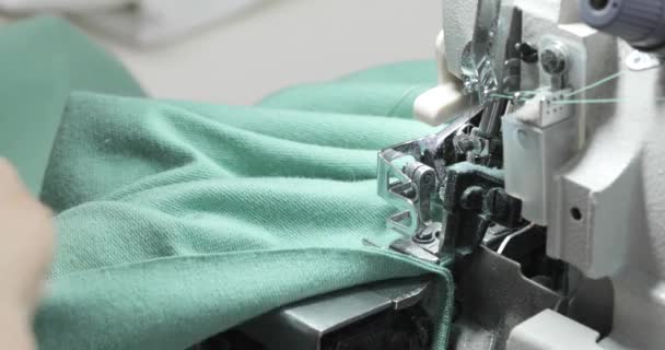 Máquina de coser Overlock. Manos femeninas trabajando en sastrería. Máquina de coser textil industrial automatizada. Primer plano. — Vídeos de Stock