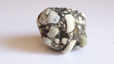 Yuvarlak şekilli bir yapı malzemesi. Taşlar katrana dönüşmüş..