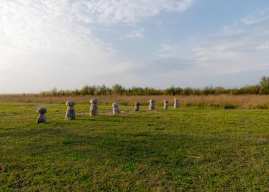 Çayırdaki ahşap figürler park yerindeki plajı sınırlıyor, doğada sonbahar renkleri var.
