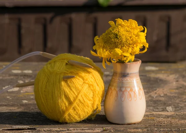 photo with old vase and ball of yarn on old wooden background, beautiful texture, blurred background, autumn colors