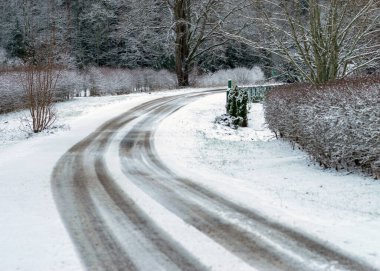 Kış manzarası karlı bir kır yolu ve yol kenarında karla kaplı ağaçlarla, kış günü