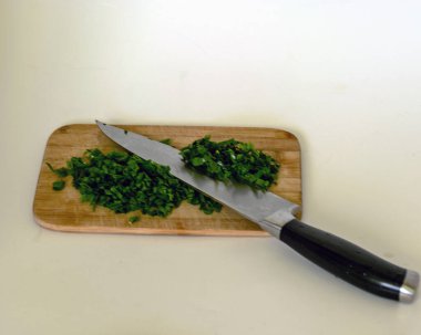 Tahta, bıçak, doğranmış yeşillikler ve baharatlar, ev yapımı sağlıklı yiyecekler, yemek pişirme.