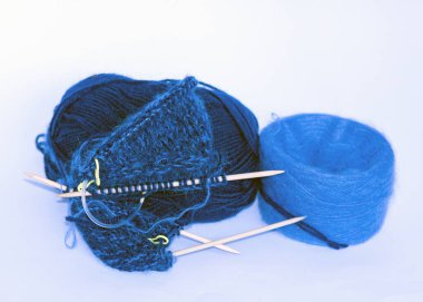Mavi iplikten örgü örmek ahşap iğneler ve mavi iplik topları, hobi olarak el işi, örgü konsepti, el yapımı