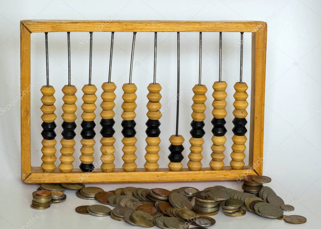 photography with various shapes, countries and values of old metal coins, against the background of an old-time wooden calculator, in ancient times, before there were still calculating machines, the abbot was very reliable for counting.