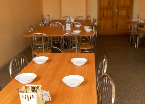 学校餐厅有桌子和椅子的图片 桌上有午餐的白色碗 — 图库照片