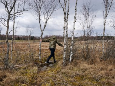Baharın başında bataklıkta bir adamla monoton bir manzara, geleneksel bataklık bitkisi.