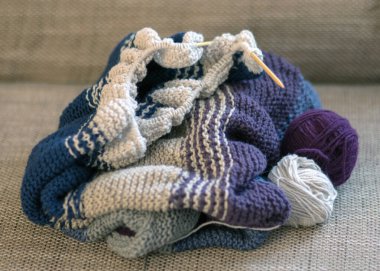 Örgü iğneli renkli bir kazak ve el yapımı bir iplik yumağı.