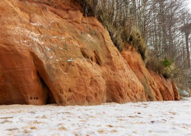 Devonian kumtaşı çıkıntılı deniz kayalığı. Fırtına sırasında, kum taşlarında oyuklar ve mağaralar oluştu, kum taşı sütunları oluşturuldu, Salacgriva bölgesindeki Ezurgu kayalıkları, Liepupe bölgesi, Letonya