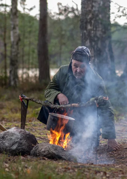 Ormanda Kamp Ateşi Yakmaya Çalışan Bir Adam Kamp Ateşinin Üzerinde — Stok fotoğraf