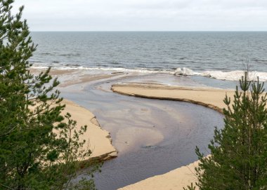 Nehrin deniz manzarası, kış günü, deniz kıyısında buz şekilleri, bulutlu hava, bulanık gökyüzü.