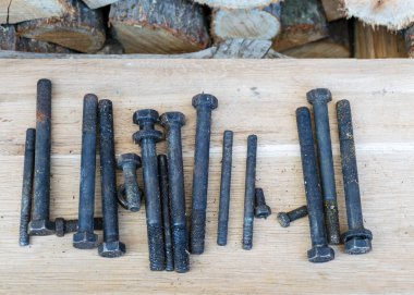 Ahşap arka planda eski ve antika vidalar, paslı aletler, metal atıkları, hurda metaller.