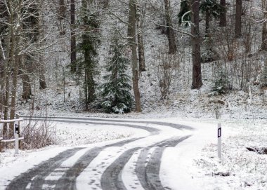 Kış manzarası karlı bir kır yolu ve yol kenarında karla kaplı ağaçlarla, kış günü