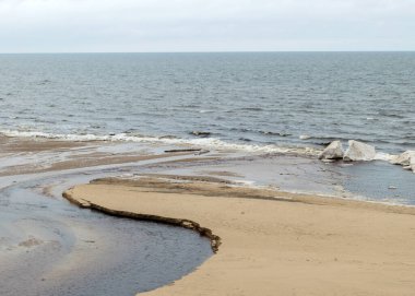 Nehrin deniz manzarası, kış günü, deniz kıyısında buz şekilleri, bulutlu hava, bulanık gökyüzü.
