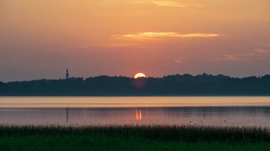 Şafakta, alacakaranlıkta gölde huzurlu bir yaz manzarası, gün doğumundan önce gökyüzünün renkleri, gölde gün doğumu, Burtnieki Gölü, Letonya