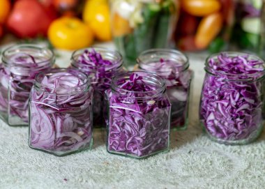 Dilimlenmiş kırmızı lahana ve soğanlı cam kavanozlar ev konservesi için hazırlanmış sebzeler, sonbahar hasat zamanı, sonbahar