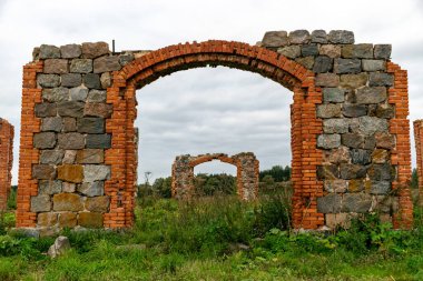 Taş ve tuğla ahır kalıntıları olan arazi, kırmızı tuğlalarla örülmüş eski taş temeller.