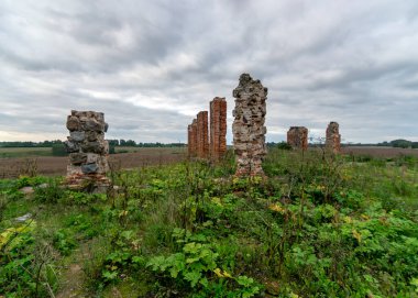 Taş ve tuğla ahır kalıntıları olan arazi, kırmızı tuğlalarla örülmüş eski taş temeller.