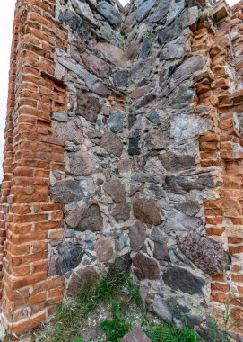Taş ve tuğla ahır kalıntıları olan arazi, kırmızı tuğlalarla örülmüş eski taş temeller.