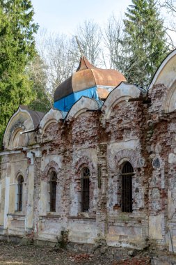 Galgauskas St. John Vaftizci Ortodoks Kilisesi çalıların ve çalıların arasında. Ağaçların tepesinde çan kulesini görebilirsiniz, Gulbene bölgesi, Letonya