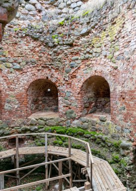 Erken bahar manzarası, kırmızı tuğla ve kaya kalıntıları, harabe taş kale parçaları, Ergeme kalesi kalıntıları, Valka bölgesi, Letonya