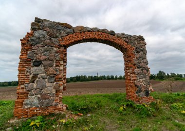 Taş ve tuğla ahır kalıntıları olan arazi, kırmızı tuğlalarla örülmüş eski taş temeller.