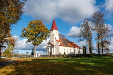 Sonbaharda beyaz bir kır kilisesi, sonbahar renklerinde ağaçlar, sonbaharda harika doğa, Rubene kilisesi, Valmiera bölgesi, Letonya