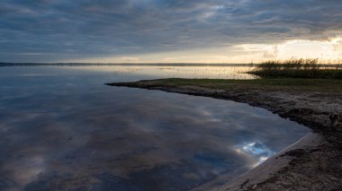 Göl kenarında harika bir gün batımı, sonbahar manzarası, göl yüzeyine yansıyan gökyüzü, suda güzel yansımalar, Burtnieki Gölü, Letonya