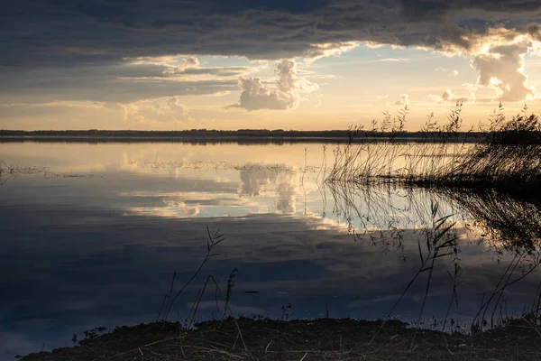 Göl kenarında harika bir gün batımı, sonbahar manzarası, güneş ışınları gölün sakin yüzeyi, Burtnieki Gölü, Letonya