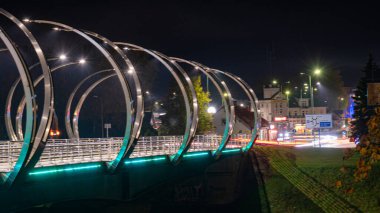 Renkli köprü ışıklandırmasıyla sonbahar manzarası, akşam alacakaranlığı, güzel, bulanık ışık nesneleri, Gauja, Valmiera, Letonya üzerindeki köprü